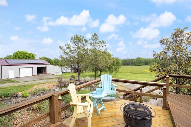 wooden terrace with an outbuilding, a fire pit, and a garage