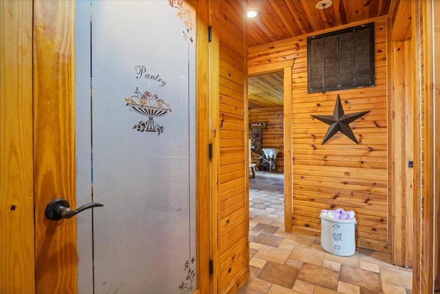 hallway with wood walls and wood ceiling