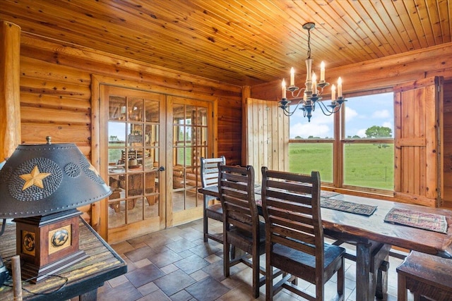 dining room featuring a notable chandelier, wooden ceiling, rustic walls, and french doors