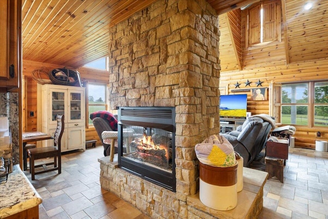 living room featuring wooden ceiling, a fireplace, a towering ceiling, and a healthy amount of sunlight