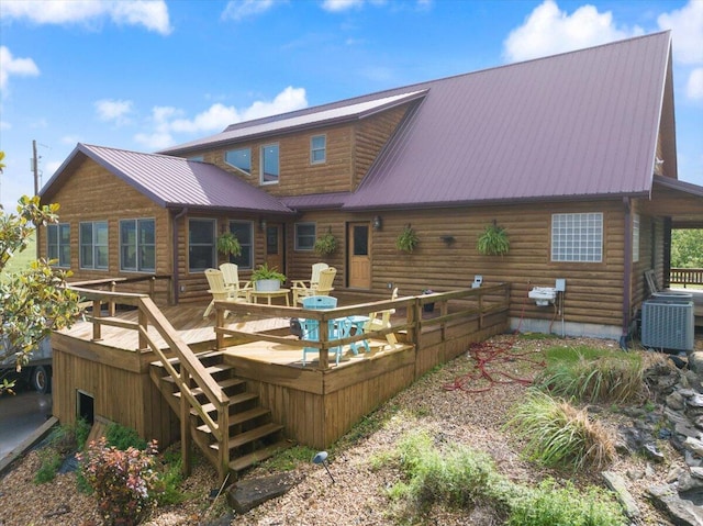 rear view of property with a wooden deck and cooling unit