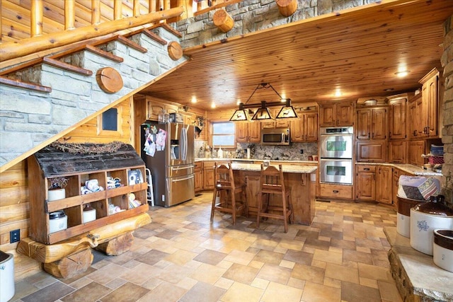 kitchen with a breakfast bar, wooden ceiling, a kitchen island with sink, decorative backsplash, and stainless steel appliances