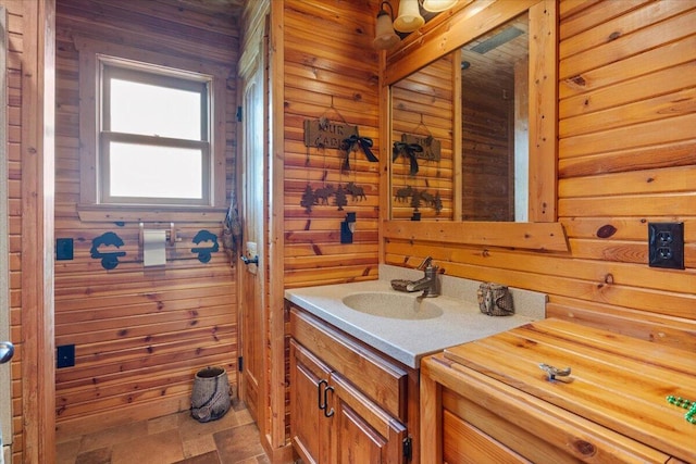 bathroom featuring vanity and wooden walls