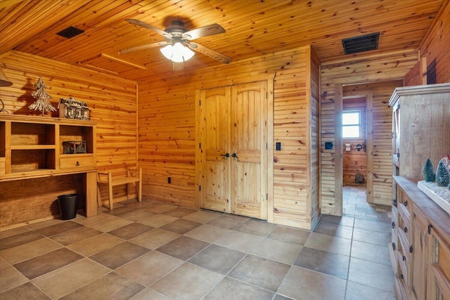 unfurnished office with tile patterned floors, ceiling fan, wood ceiling, and wooden walls