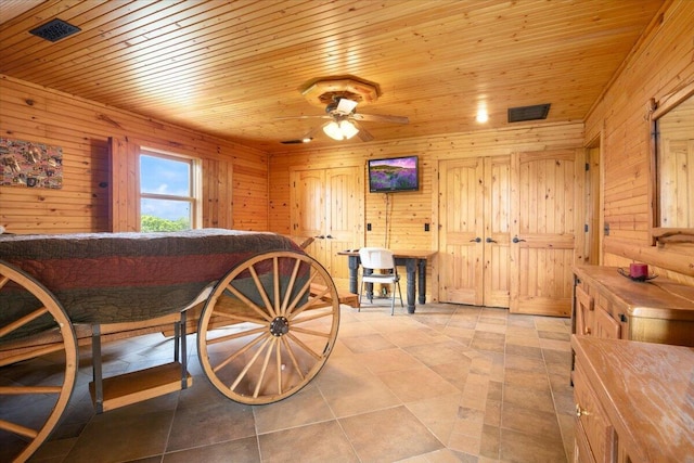 dining room featuring ceiling fan, light tile patterned floors, wood ceiling, and wooden walls