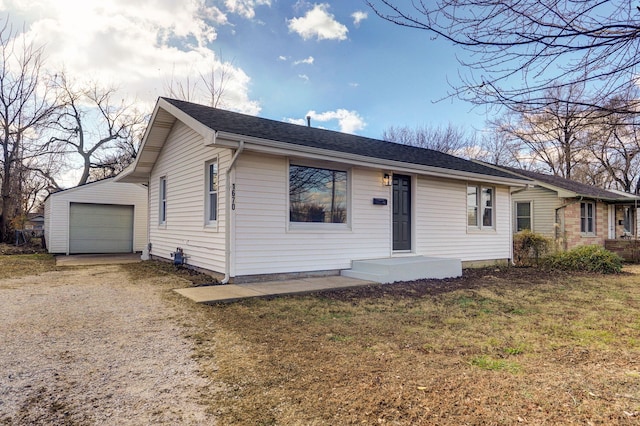 ranch-style home with a front lawn, an outdoor structure, and a garage