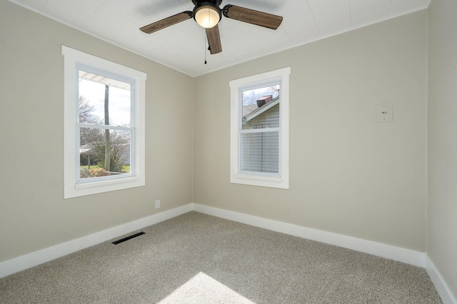 unfurnished room with ceiling fan and carpet