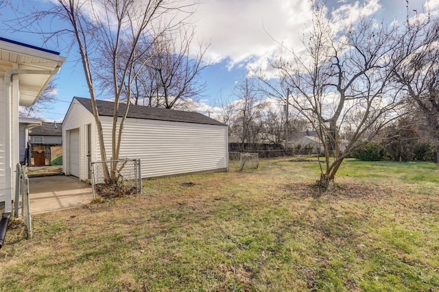 view of yard with a garage and an outbuilding