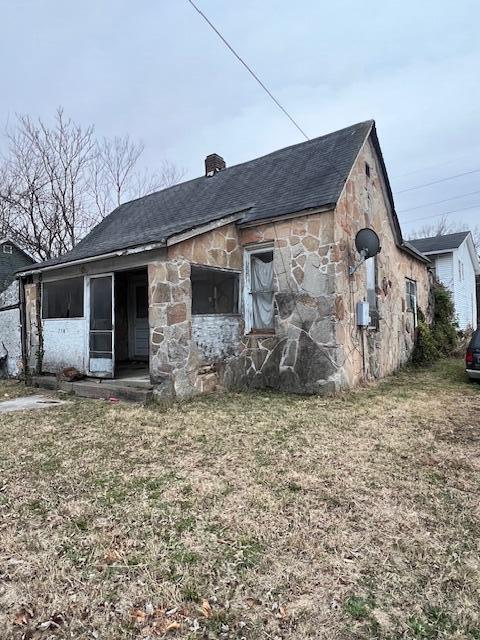 rear view of property featuring a lawn