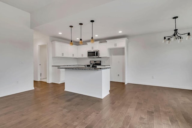 kitchen with recessed lighting, stainless steel microwave, dark wood finished floors, and white cabinetry