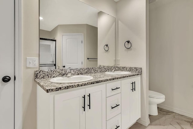 bathroom featuring double vanity, toilet, marble finish floor, and a sink