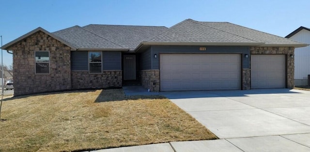 ranch-style house featuring a front lawn, concrete driveway, a garage, and roof with shingles