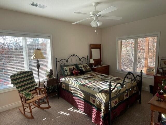 carpeted bedroom featuring ceiling fan and multiple windows