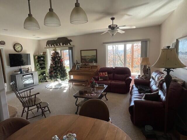 carpeted living room featuring ceiling fan