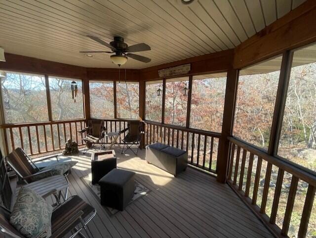 sunroom featuring ceiling fan and wooden ceiling