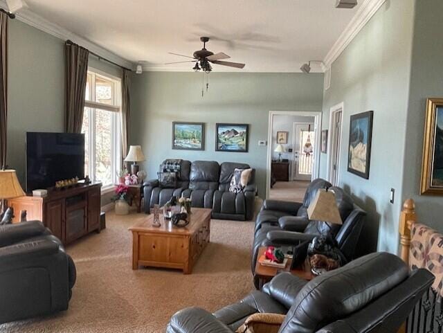 living room featuring ceiling fan, crown molding, and light carpet