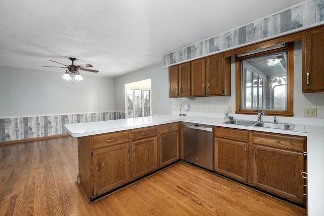 kitchen featuring dishwasher, kitchen peninsula, sink, and a wealth of natural light