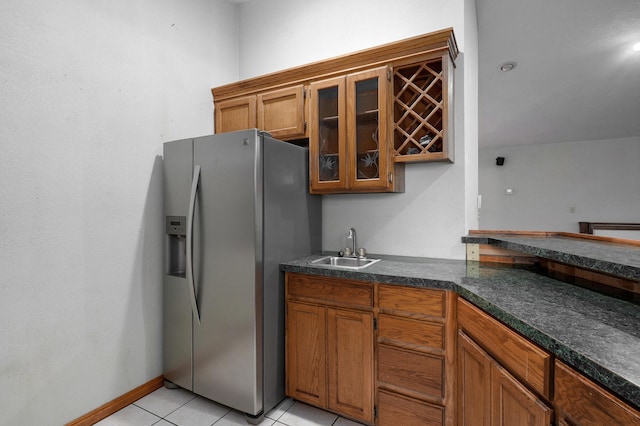 kitchen featuring stainless steel fridge, sink, and light tile patterned floors