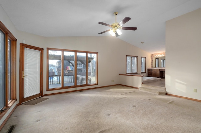 unfurnished living room featuring ceiling fan, light colored carpet, and vaulted ceiling