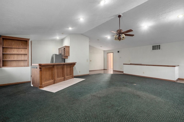 kitchen with light carpet, vaulted ceiling, ceiling fan, kitchen peninsula, and stainless steel refrigerator