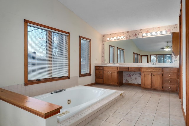 bathroom featuring ceiling fan, tile patterned floors, tiled bath, vaulted ceiling, and vanity