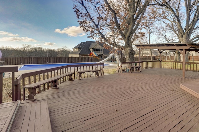 wooden deck with a fenced in pool