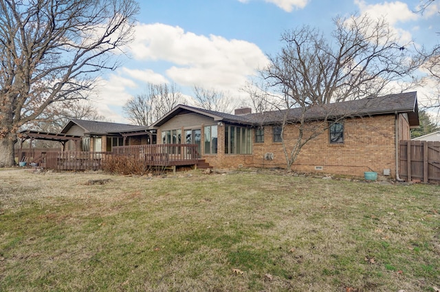 back of house featuring a deck and a lawn