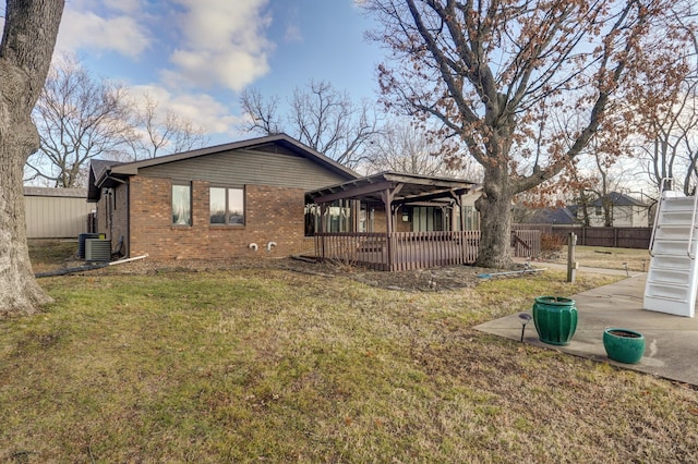 back of property featuring central air condition unit, a yard, and a deck