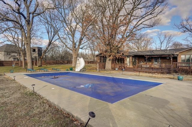 view of pool with a yard, a water slide, and a patio