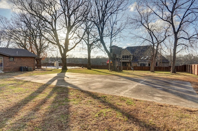 view of yard with basketball court and central AC unit