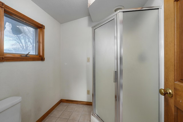 bathroom with toilet, tile patterned floors, and walk in shower