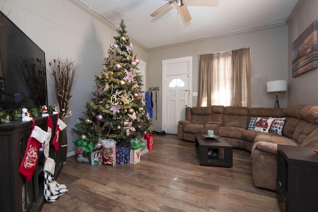 living room featuring dark hardwood / wood-style flooring, ceiling fan, and ornamental molding