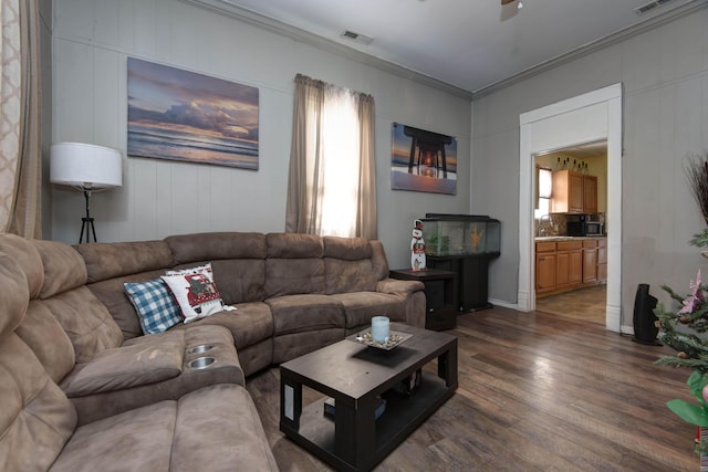 living room with crown molding, sink, ceiling fan, and dark wood-type flooring