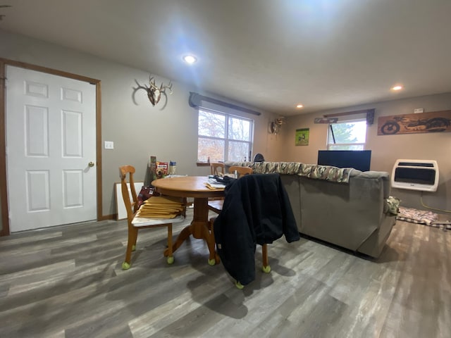 dining area with hardwood / wood-style floors, a healthy amount of sunlight, and heating unit