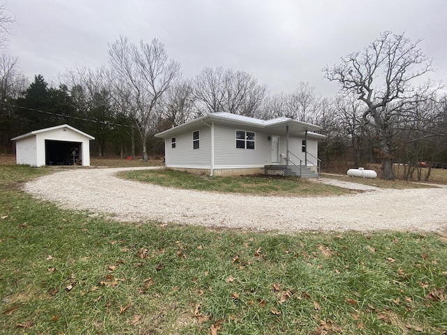 view of home's exterior with a garage, an outdoor structure, and a lawn