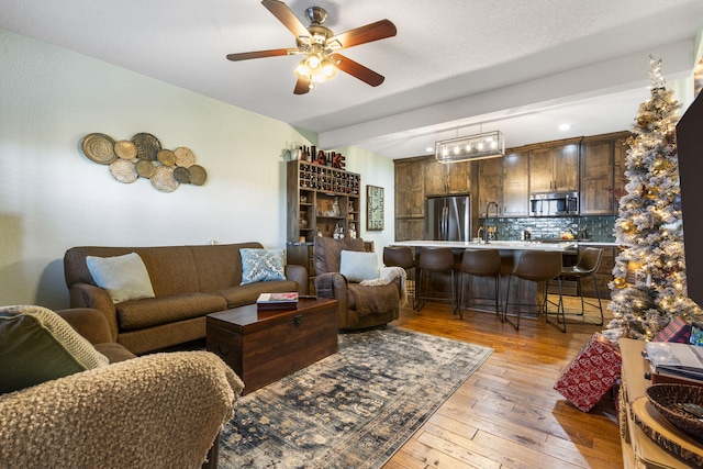 living room with light hardwood / wood-style flooring and ceiling fan