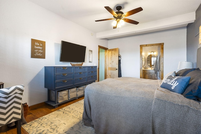 bedroom featuring ceiling fan, connected bathroom, dark hardwood / wood-style floors, and beam ceiling