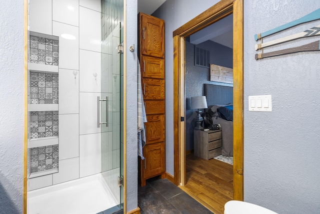 bathroom featuring wood-type flooring and an enclosed shower