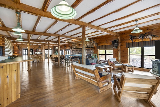 living room with beamed ceiling, dark hardwood / wood-style flooring, and wood walls