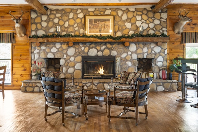 dining space featuring a fireplace, hardwood / wood-style flooring, and beamed ceiling