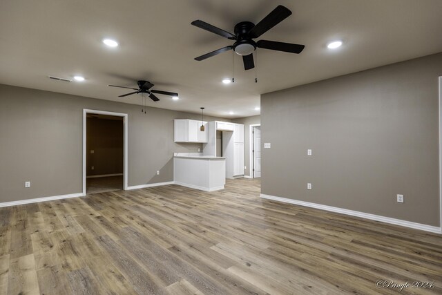 unfurnished living room featuring ceiling fan and light hardwood / wood-style flooring