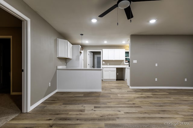 kitchen featuring white cabinets, ceiling fan, wood-type flooring, and hanging light fixtures