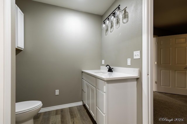bathroom with toilet, vanity, and hardwood / wood-style flooring