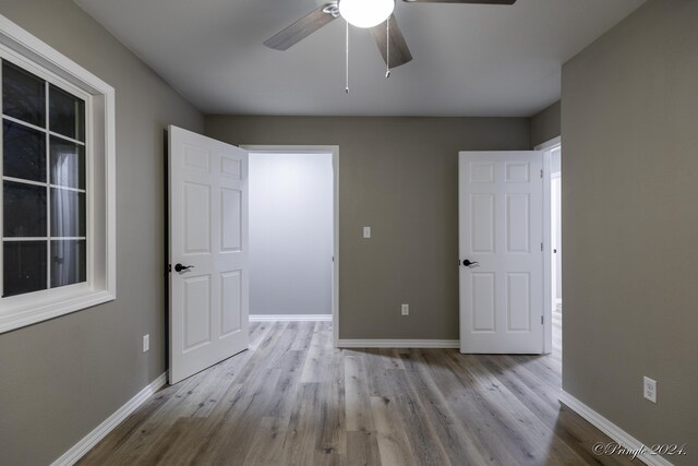 unfurnished bedroom with ceiling fan and light hardwood / wood-style floors