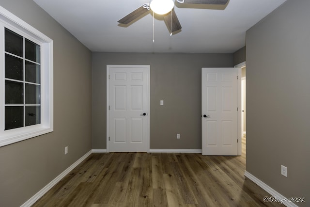 unfurnished bedroom featuring dark hardwood / wood-style floors and ceiling fan