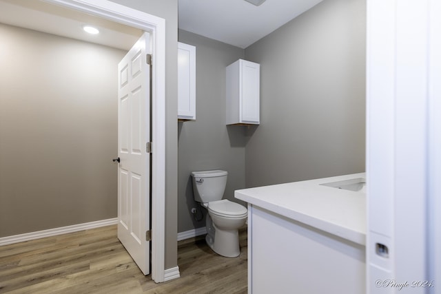 bathroom with vanity, hardwood / wood-style flooring, and toilet
