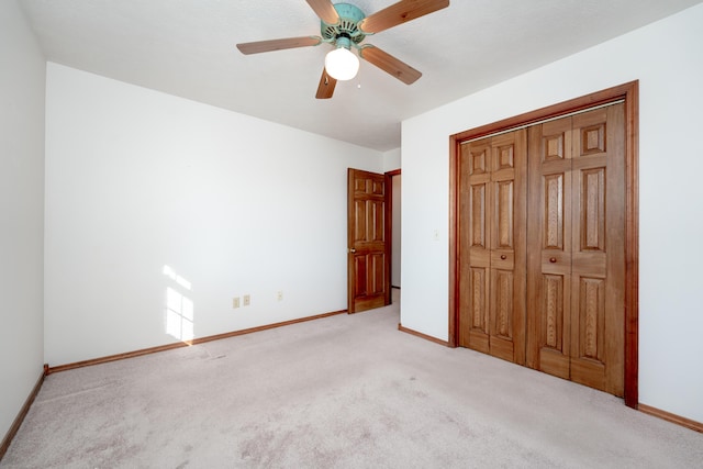 unfurnished bedroom with ceiling fan, light carpet, and a closet