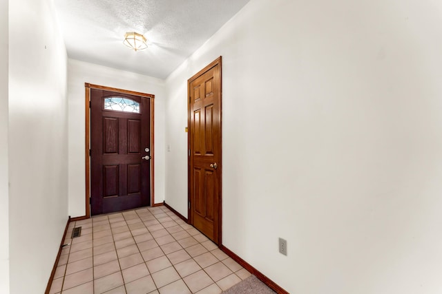 tiled foyer with a textured ceiling