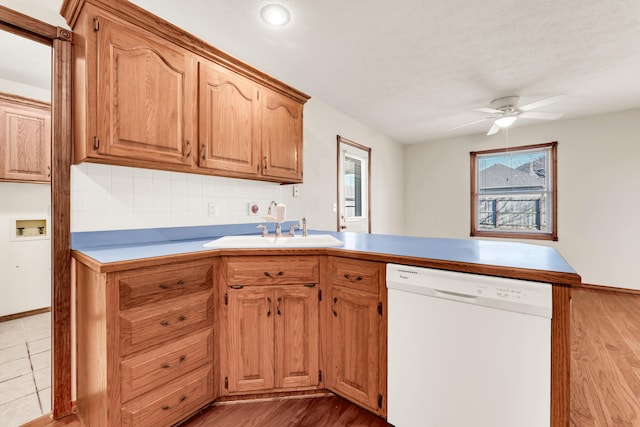 kitchen featuring white dishwasher, ceiling fan, light hardwood / wood-style floors, and sink