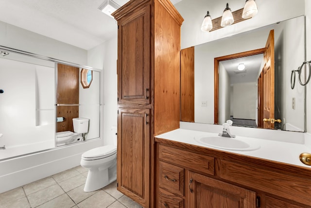 full bathroom with tile patterned floors, vanity, bath / shower combo with glass door, and toilet